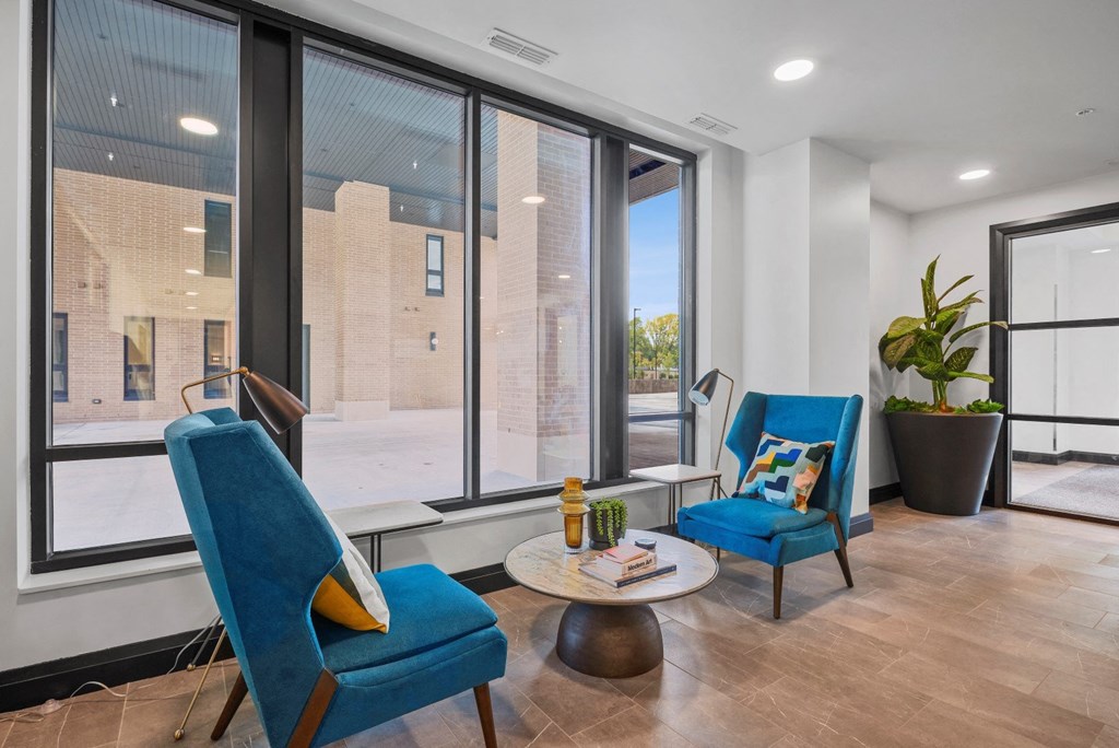 a living room with two blue chairs and a large window