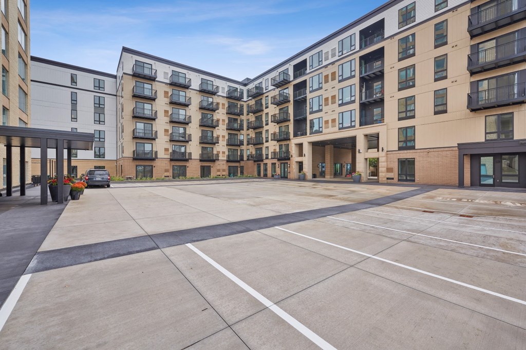 an empty parking lot in front of an apartment building