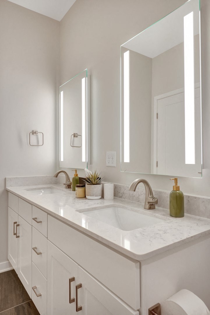 a white bathroom with two mirrors and two sinks