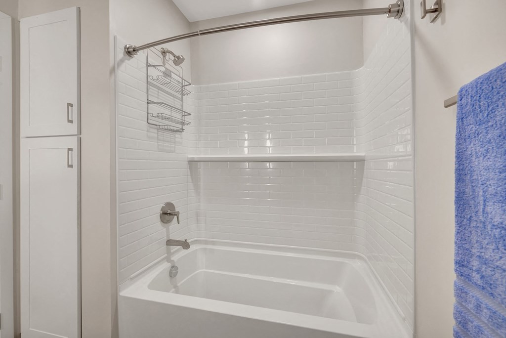 a bathroom with a white tub and a white shower curtain