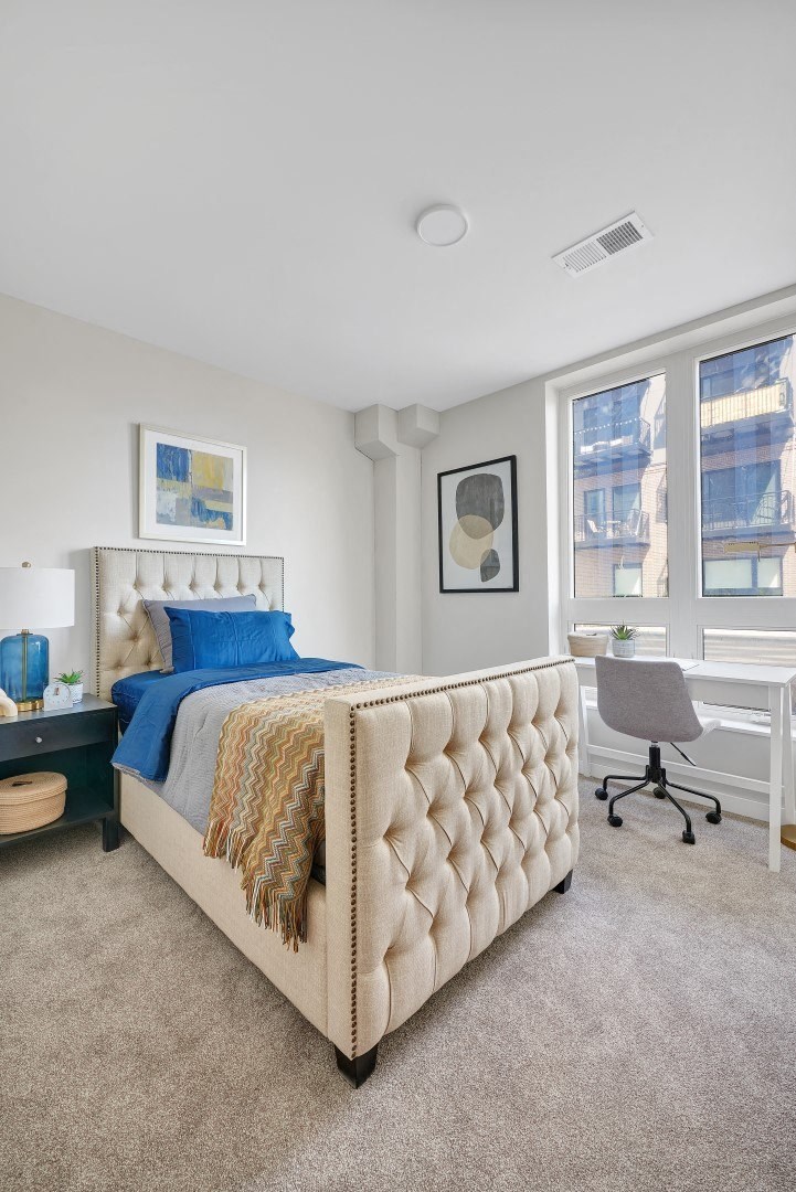 a bedroom with a bed and a desk with a chair