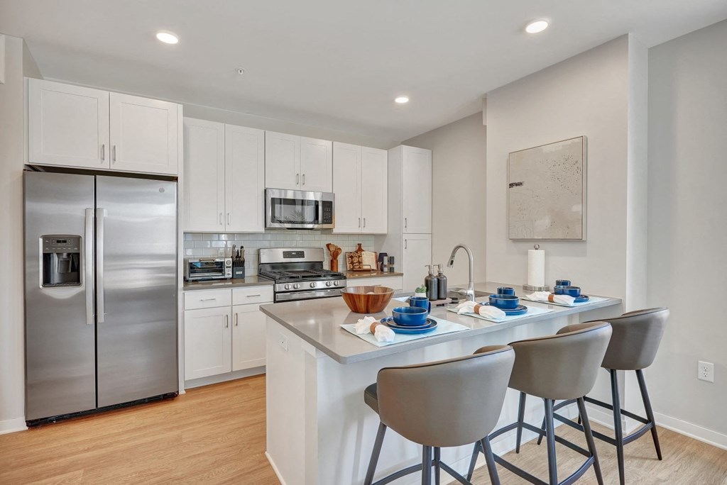 a kitchen with white cabinetry and stainless steel appliances