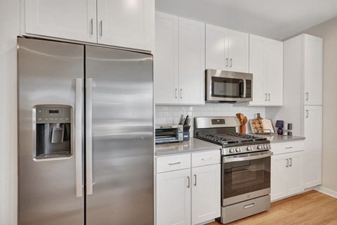 a kitchen with white cabinetry and stainless steel appliances