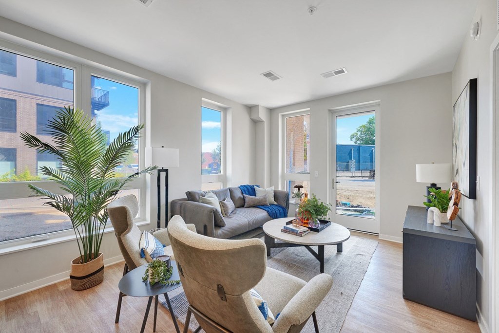 a living room with a couch table and chairs and a large window