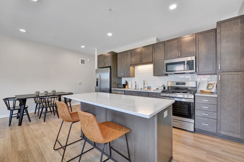 a kitchen with a large center island with a white quartz top