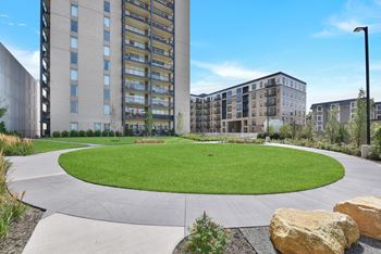 A large grassy area in front of apartment buildings.