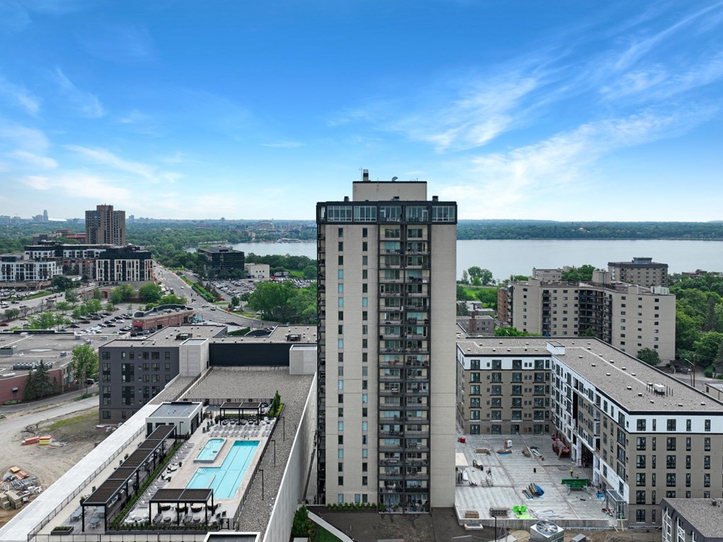 an aerial view of a tall building with a pool in front of it