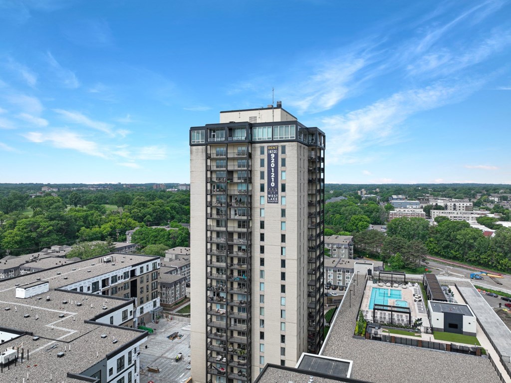 an aerial view of a tall building with a pool in front of it