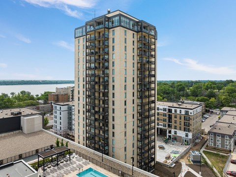 an aerial view of a tall building with a pool in front of it