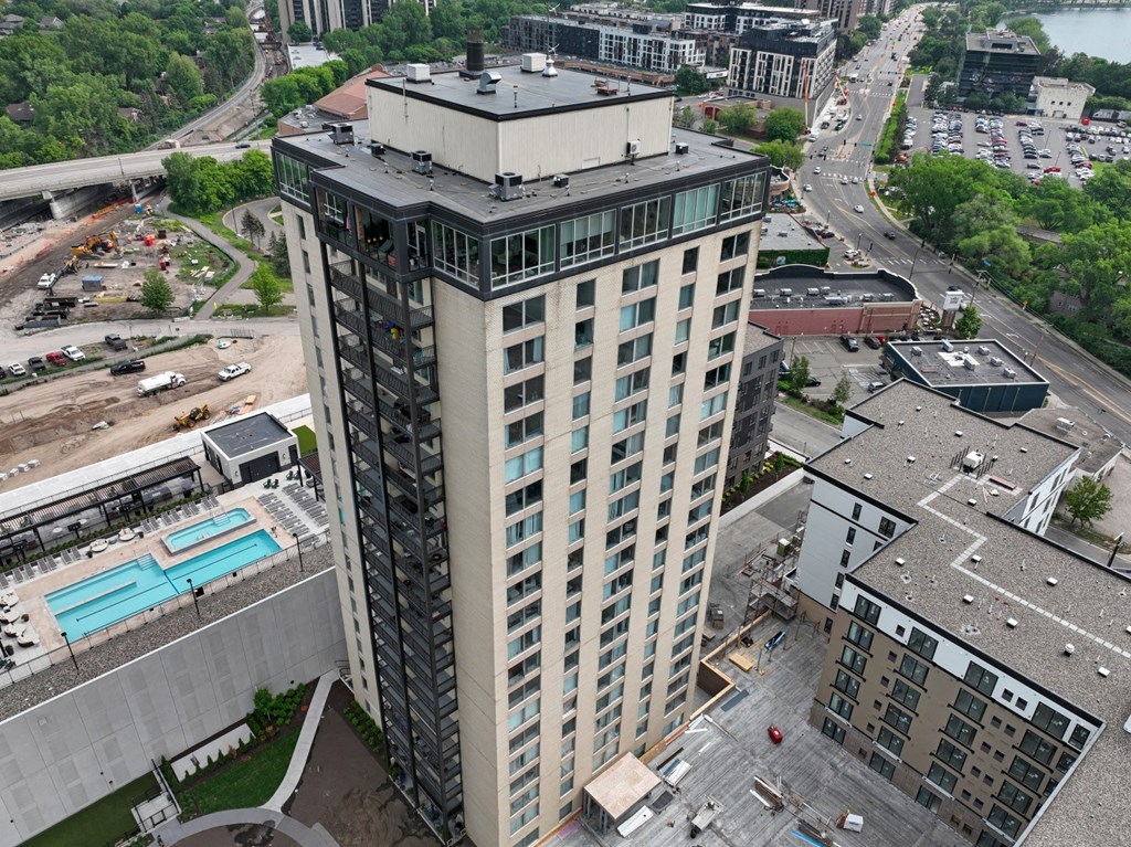 a tall building with many windows and a blue pool in front of it