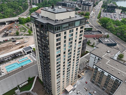 a tall building with many windows and a blue pool in front of it