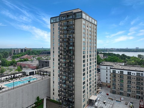 an aerial view of a tall building with a pool in front of it