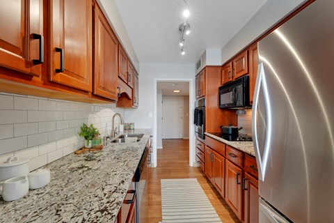 a kitchen with granite counter tops and wooden cabinets  at The Original at West Lake Quarter, Minneapolis, 55416