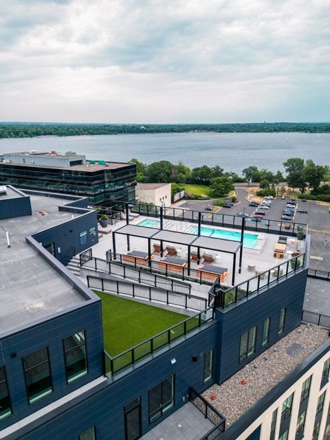a view of the pool area from the top of a building with a lake in the background