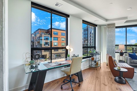 A modern living room with a glass table and a view of the city.
