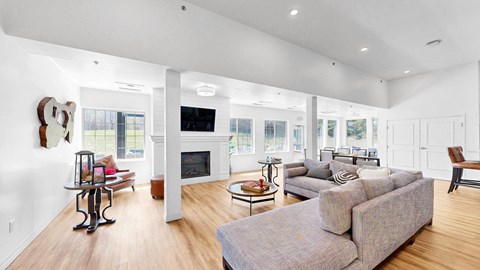A living room with a grey couch and a fireplace.