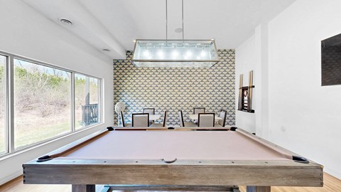 A pool table in a room with a patterned wallpaper.