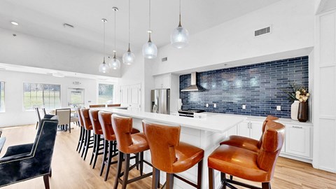 A kitchen with a bar area and chairs.