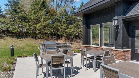 A patio with a table and chairs is set up outside a house.