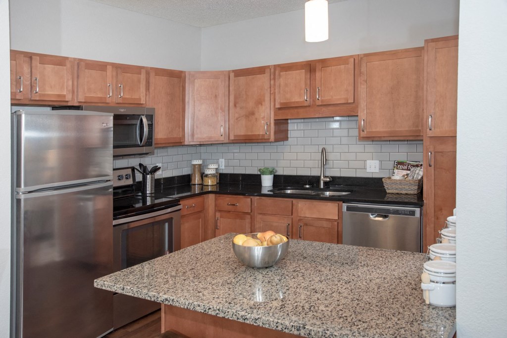 Upgraded kitchen with granite countertops, tile backsplash and stainless steel appliances