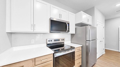 A kitchen with white cabinets and stainless steel appliances.