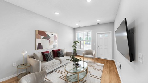 A modern living room with a glass coffee table and a large painting on the wall.