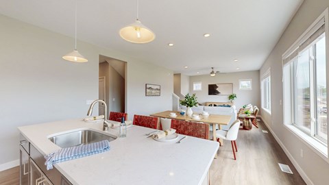 A kitchen with a white countertop and a dining area with a table and chairs.