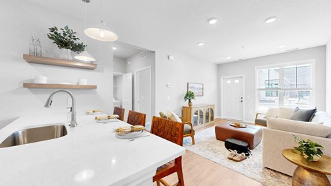 A modern kitchen with a dining area and a living room.