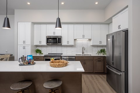 A modern kitchen with white cabinets and a stainless steel refrigerator.