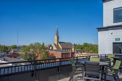 A church steeple is visible behind a building with a balcony.