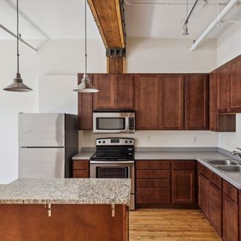 A kitchen with wooden cabinets and a granite countertop.