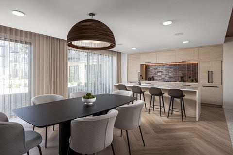 A modern dining room with a large table and chairs.