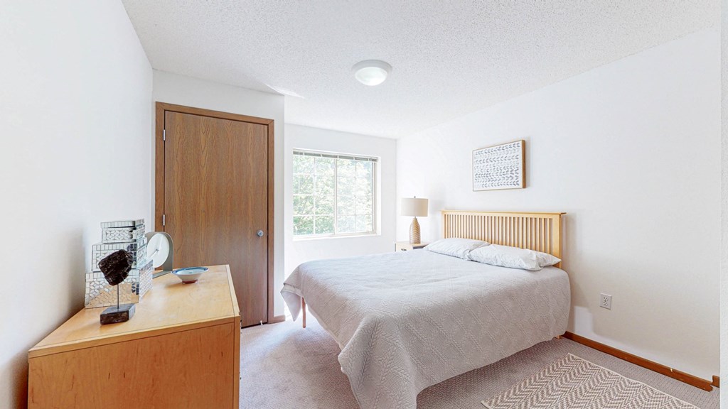 a bedroom with a bed and a dresser and a window