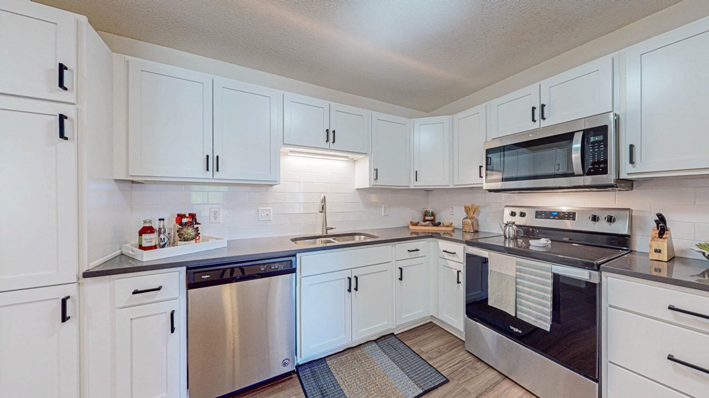 a kitchen with white cabinets and stainless steel appliances