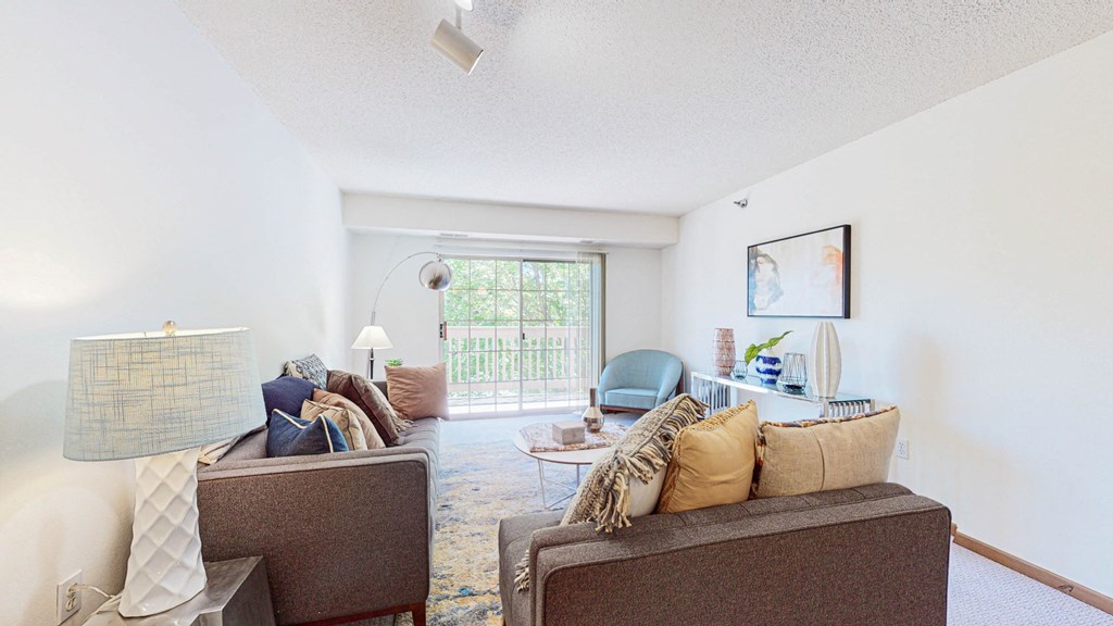 a living room with couches and chairs and a sliding glass door