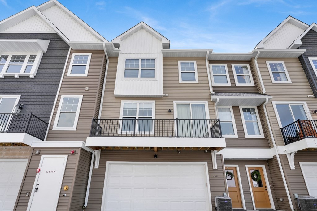 a row of houses with white garage doors