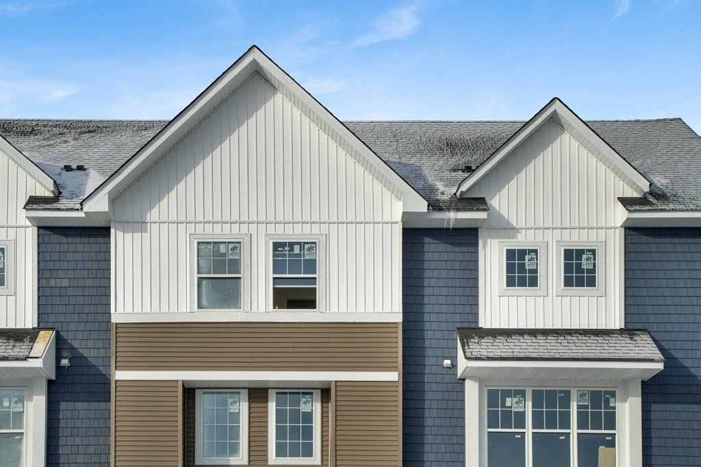 a row of houses with siding and a blue sky