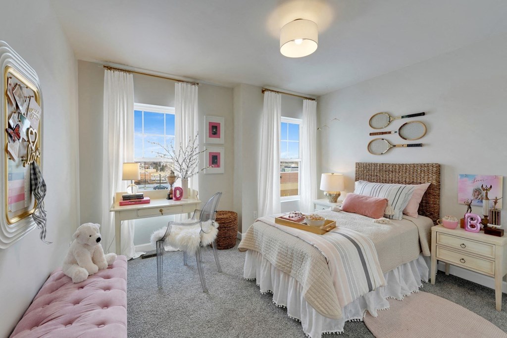 a bedroom with a bed and a desk and a window