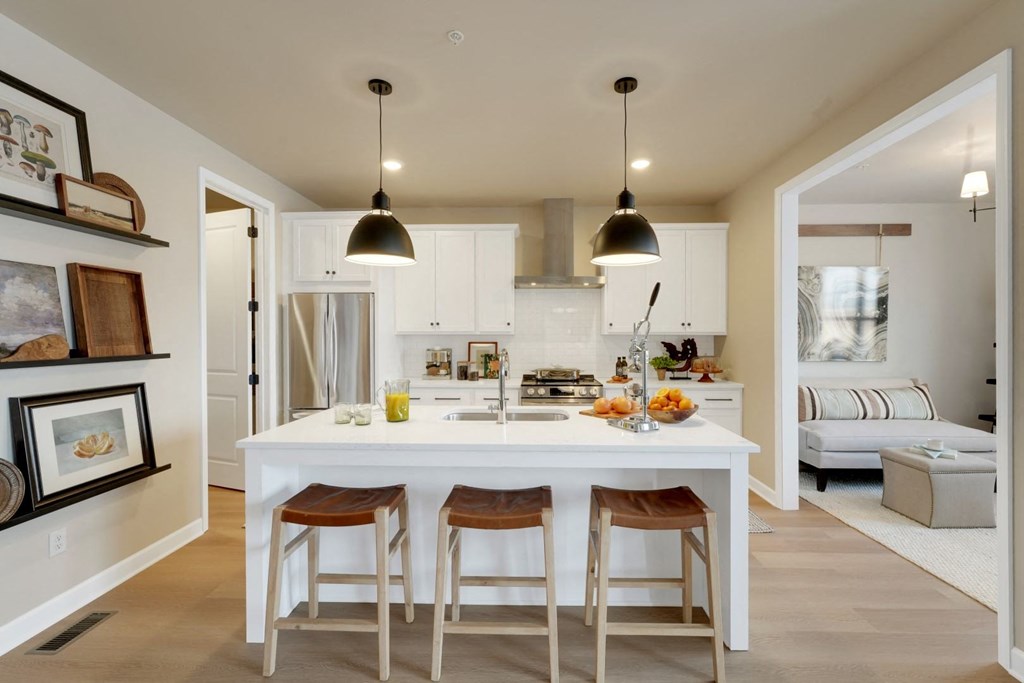 a kitchen with a white island and three stools
