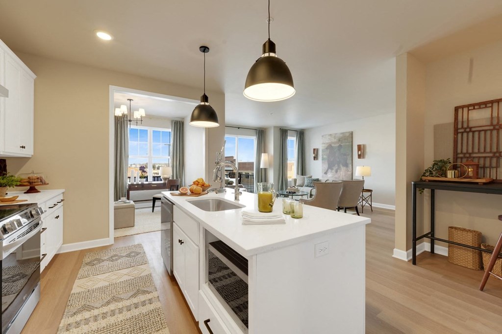 an open kitchen and living room with a white counter top
