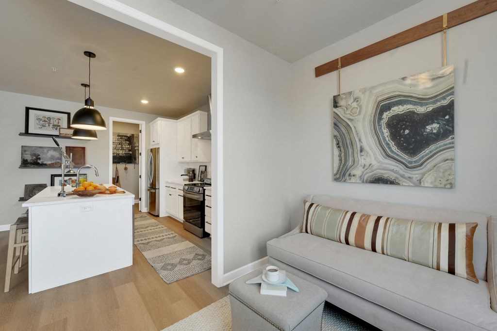 a living room with a couch and a kitchen