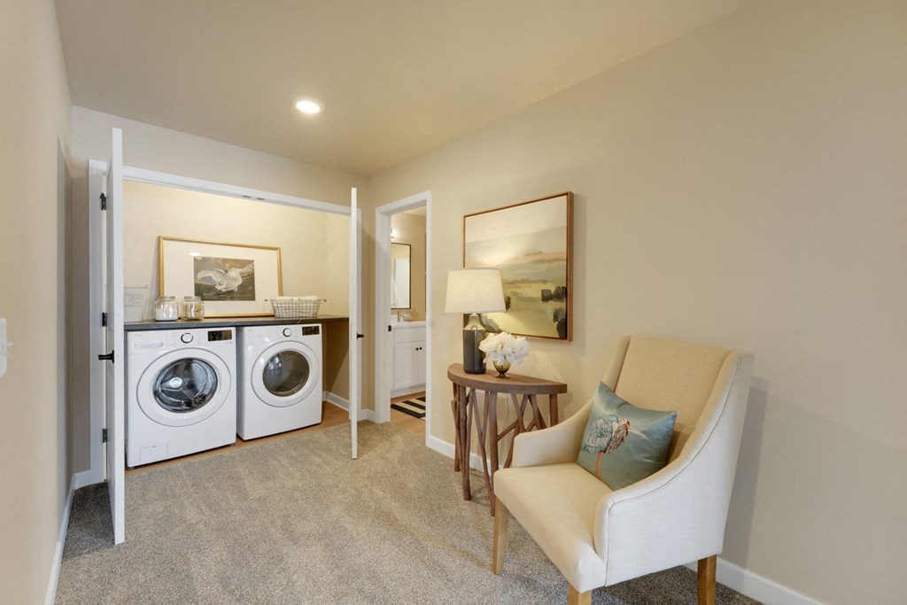 a living room with a washing machine and a dryer in it