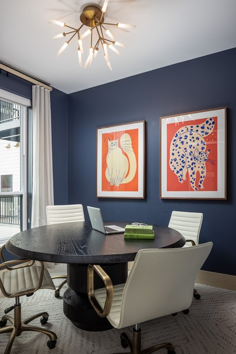 A dining room with a round table and chairs.