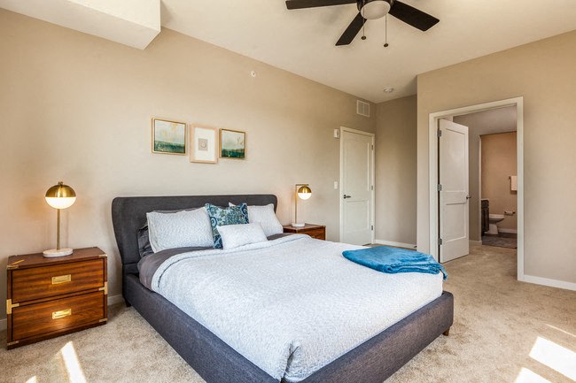 a bedroom with a large bed and a ceiling fan