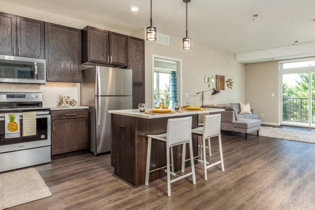 a kitchen with a center island and a bar with stools