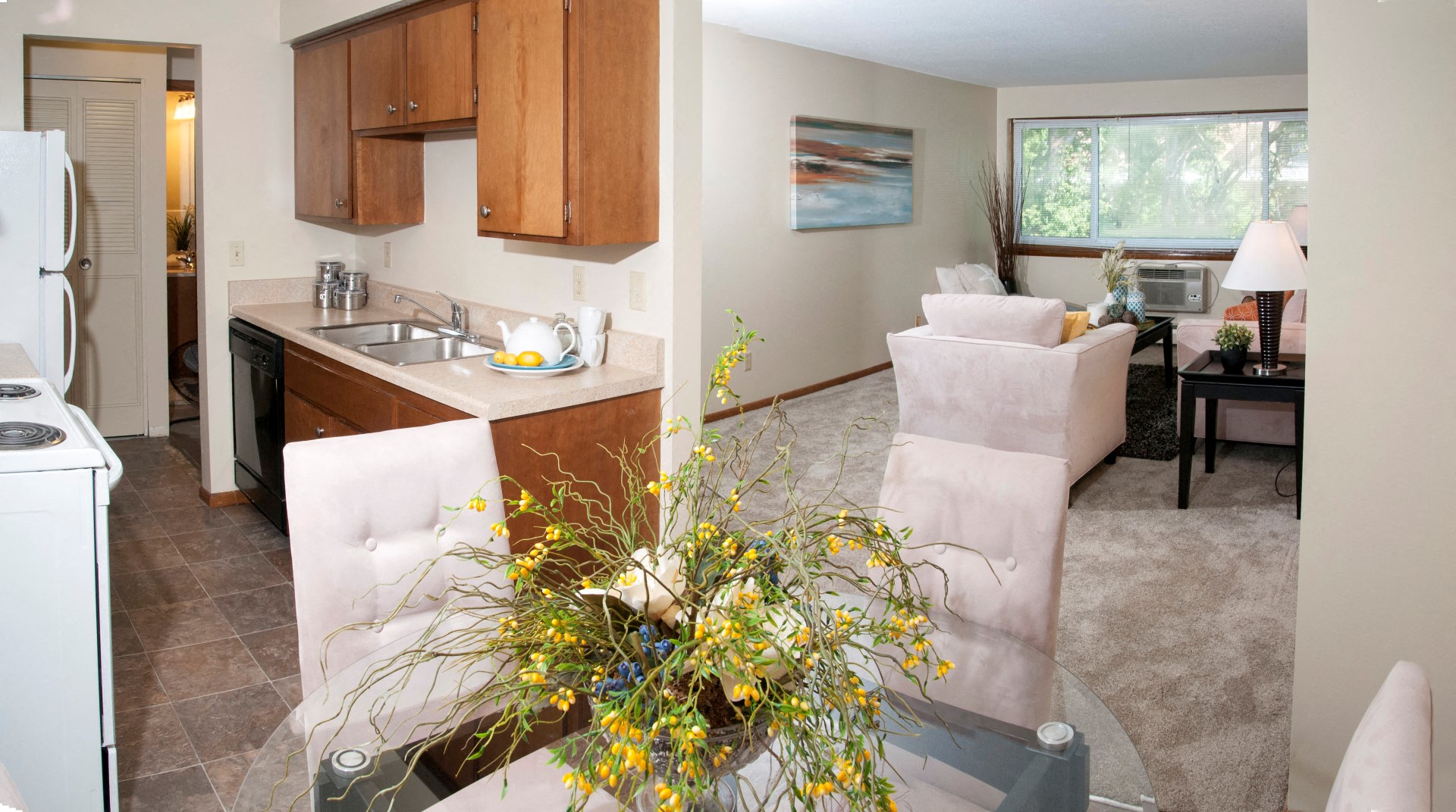 a living room and a kitchen with a table and chairs