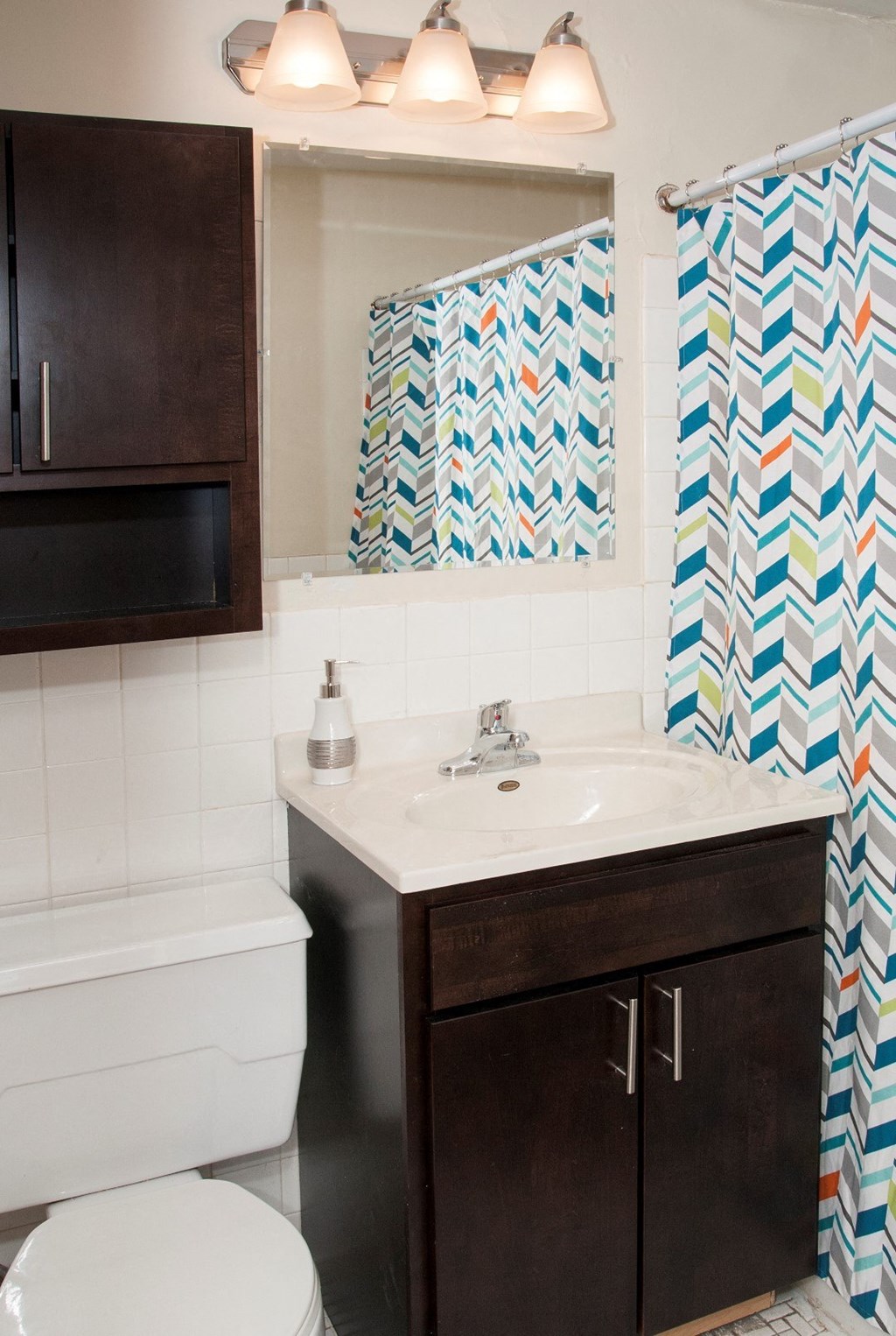 a bathroom with a shower curtain and a sink and a toilet
