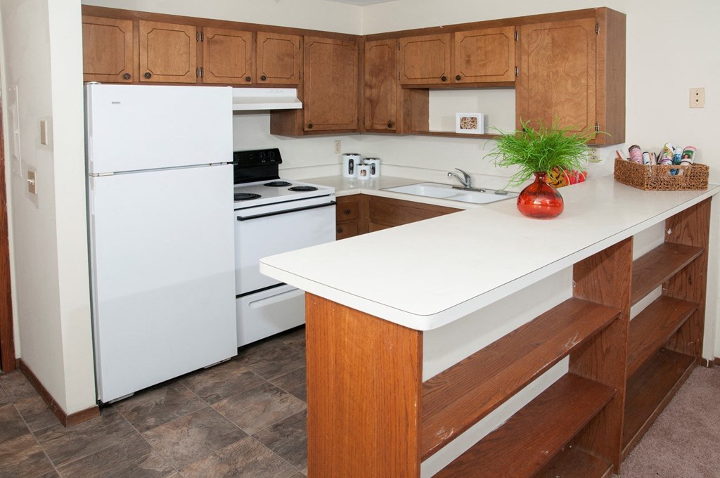 a kitchen with white appliances and wooden cabinets