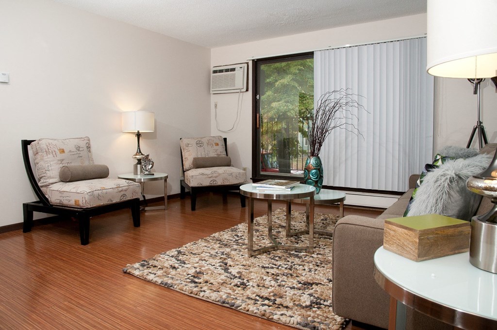 a living room with couches and chairs and a window