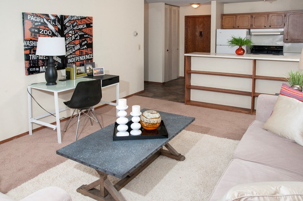 a living room with a couch and a table and a kitchen